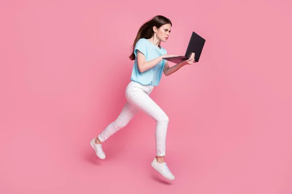Full kropp foto av fokuserad flicka hoppa använda bärbar dator försäljning bära blå vita sneakers isolerad pastell färg bakgrund — Stockfoto