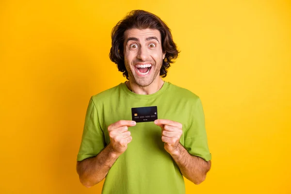Retrato foto de homem feliz mostrando cartão de plástico banco sorrindo isolado no fundo cor amarela vibrante — Fotografia de Stock