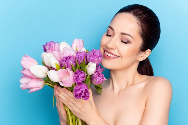 Foto de mujer atractiva sonrisa feliz celebrar flores ramo vacaciones de primavera presente aislado sobre fondo de color azul —  Fotos de Stock