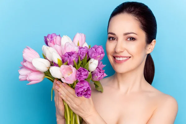 Foto de mujer atractiva sonrisa feliz celebrar flores tulipanes vacaciones de primavera presente aislado sobre fondo de color azul —  Fotos de Stock