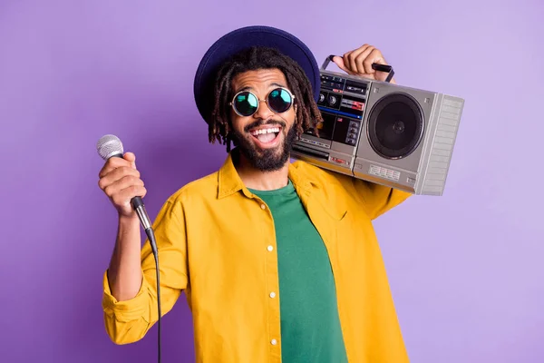 Retrato de piel oscura positiva persona dientes delanteros brecha sonrisa mantenga micrófono caja boom aislado sobre fondo de color púrpura —  Fotos de Stock