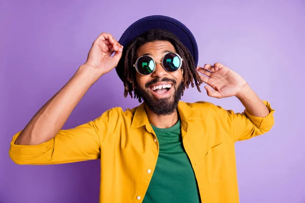 Retrato de despreocupado pessoa de pele escura dançando divirta-se dente sorriso headwear isolado no fundo de cor roxa — Fotografia de Stock