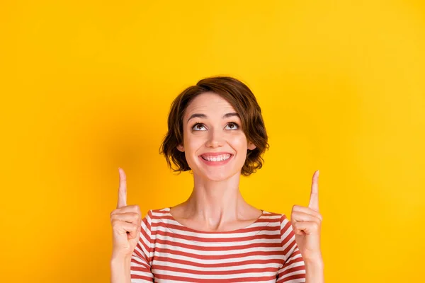 Close-up foto van aantrekkelijke dame op zoek lege ruimte geven twee vinger omhoog geïsoleerd op levendige gele kleur achtergrond — Stockfoto