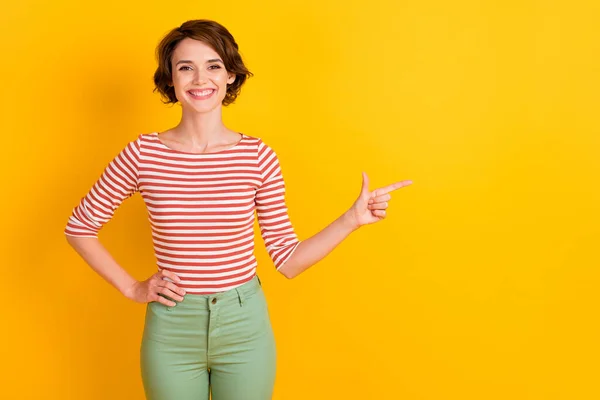 Foto de agradable señora satisfecha dedo dedo vacío espacio brazo en la cintura aislado sobre fondo de color amarillo brillante —  Fotos de Stock