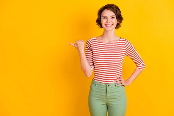 Foto de retrato de la alegre chica feliz con el pelo bob mostrando en el espacio en blanco sonriendo aislado sobre fondo de color amarillo brillante —  Fotos de Stock