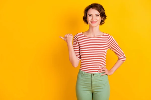 Foto retrato de menina com cabelo bob apontando para o espaço vazio sorrindo isolado no fundo de cor amarelo vívido — Fotografia de Stock