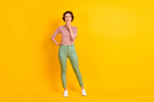 Full length body size photo of thoughtful curious girl thinking about idea looking at blank space isolated on vivid yellow color background — Stock Photo, Image