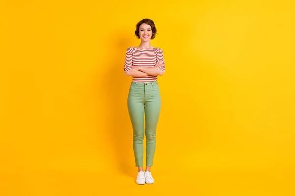 Volledige lichaamslengte foto van meisje dragen casual kleding glimlachen met gevouwen handen geïsoleerd op fel gele kleur achtergrond — Stockfoto