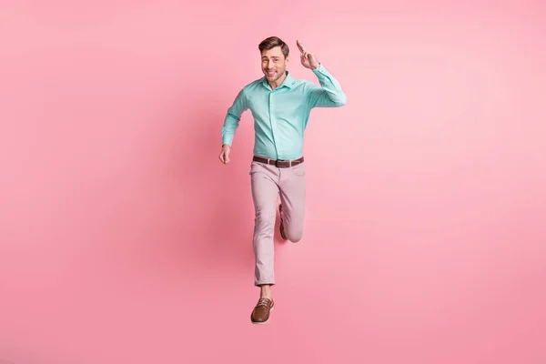 Pleine longueur photo de charismatique jeune homme courir vous sauter air charme sourire isolé sur fond rose pastel — Photo