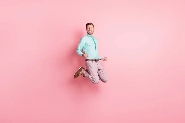 Full size foto van vrolijke vrolijke man houden vuisten winnaar springen lucht dragen formele outfit geïsoleerd op pastel roze kleur achtergrond — Stockfoto
