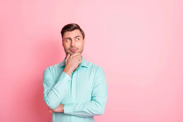 Foto retrato de empresário inteligente tocando queixo olhando espaço vazio isolado no fundo cor-de-rosa pastel — Fotografia de Stock