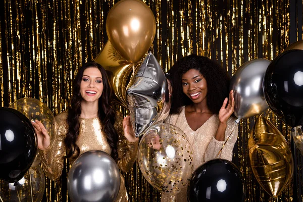 Photo of two brown haired ladies festive mood balloons smile party dress isolated on shine bright tinsel background — Stock Photo, Image