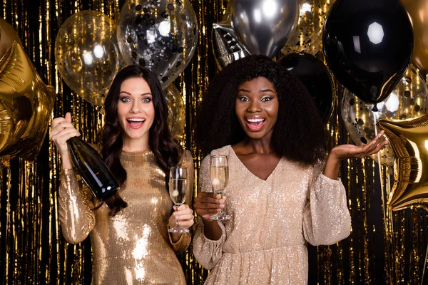 Photo de remorquage étonnantes dames festives tenir verres champagne bouteille partie isolé sur brillant paillettes fond lumineux — Photo