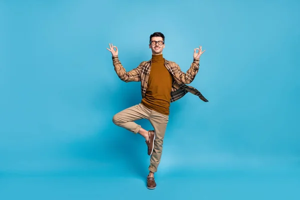 Pełnowymiarowe zdjęcie młodego funky zabawny uśmiech pozytywny człowiek robi jogę pokazując okay znak izolowane na tle niebieskiego koloru — Zdjęcie stockowe