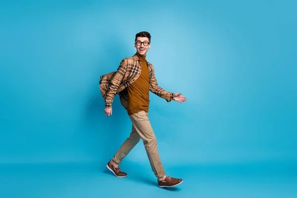 Full size profil boczny zdjęcie młody przystojny szczęśliwy pozytywny pogodny człowiek przejść spacer odizolowany na tle niebieskiego koloru — Zdjęcie stockowe