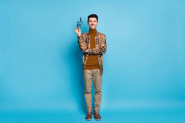 Foto de tamaño completo de joven atractivo sonriente hombre de negocios alegre con las manos cruzadas muestran gafas aisladas sobre fondo de color azul —  Fotos de Stock