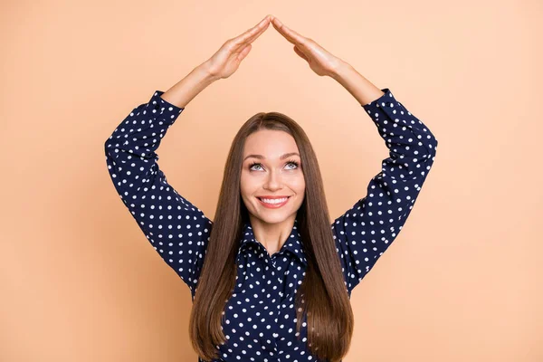 Foto de mujer joven feliz positivo celebrar la mano techo casa comprar movimiento buscar espacio vacío aislado sobre fondo de color beige —  Fotos de Stock