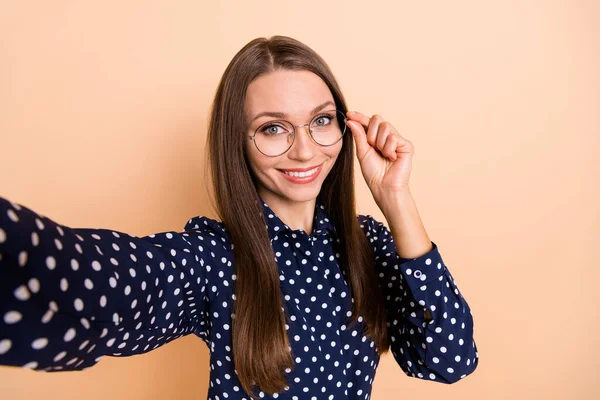 Foto da jovem mulher feliz sorriso positivo mão toque óculos fazer selfie isolado sobre cor bege fundo — Fotografia de Stock