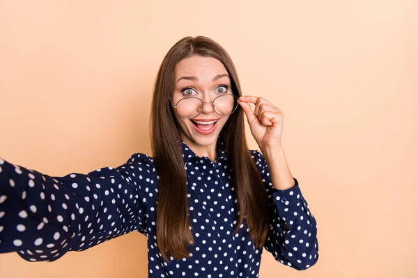 Foto da jovem mulher feliz sorriso positivo surpreendido surpreendido mão toque óculos fazer selfie isolado sobre cor bege fundo — Fotografia de Stock