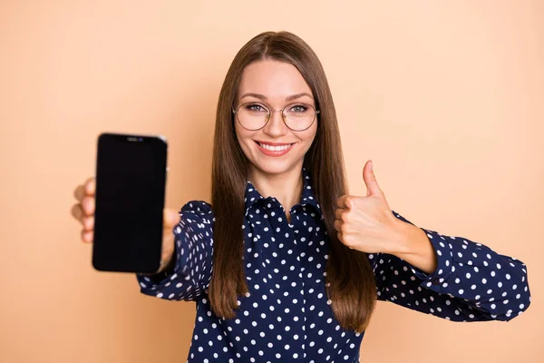 Foto da jovem mulher feliz sorriso mostrar polegar-up como anúncio conselho touchscreen celular isolado sobre cor bege fundo — Fotografia de Stock