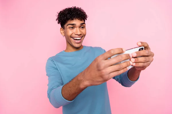 Foto de chico negro emocionado joven feliz juego de sonrisa positiva teléfono inteligente aislado sobre fondo de color pastel — Foto de Stock