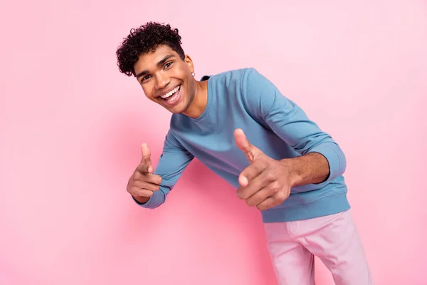 Foto retrato de un joven sonriendo señalando los dedos eligiendo seleccionarte aislado sobre fondo de color rosa pastel — Foto de Stock
