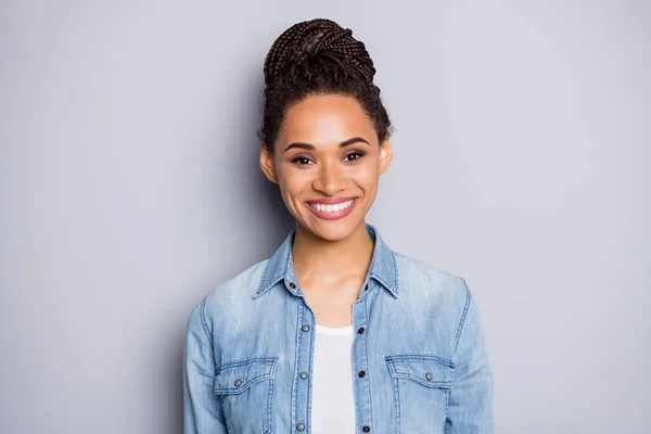 Foto portret van meisje met broodje dragen jeans shirt lachen vrolijk geïsoleerd op grijze achtergrond — Stockfoto