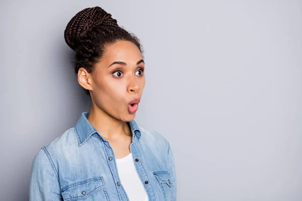 Foto retrato de menina maravilhada com bun staring abriu a boca olhando espaço em branco em roupa casual isolado no fundo de cor cinza — Fotografia de Stock