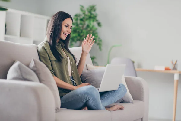 Profilo vista laterale ritratto di bella attraente ragazza allegra seduta sul divano fare videochiamata salutando a casa casa casa appartamento al coperto — Foto Stock