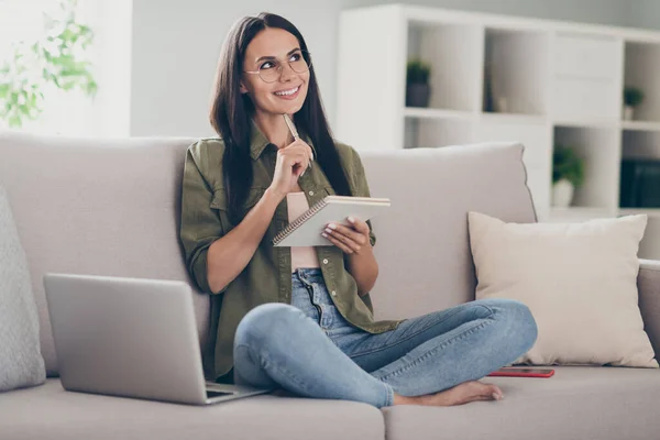 Volledig lichaam profiel zijkant foto van jonge vrolijke vrouw gelukkig positief glimlach denk droom schrijven plan to-do lijst zitten bank binnen — Stockfoto