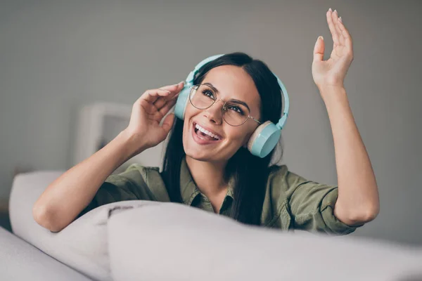 Närbild porträtt av charmiga glada dam sitter på divan lyssna stereo ljud ha kul hemma hus platt inomhus — Stockfoto