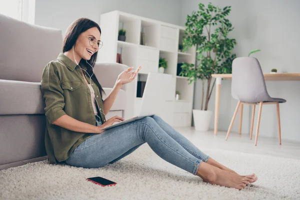 Профиль боковой вид довольно веселой девушки, сидящей на ковре с помощью ноутбука делает видеозвонок весело времяпрепровождение в доме квартиру крытый — стоковое фото
