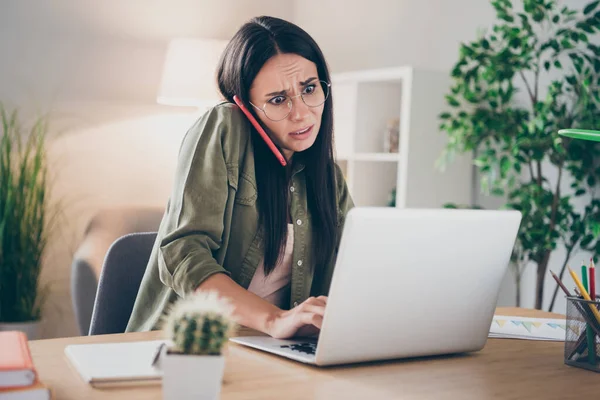 Foto de jovem atraente linda muito infeliz chateado mulher triste em óculos falar telefone trabalhando no laptop em casa — Fotografia de Stock