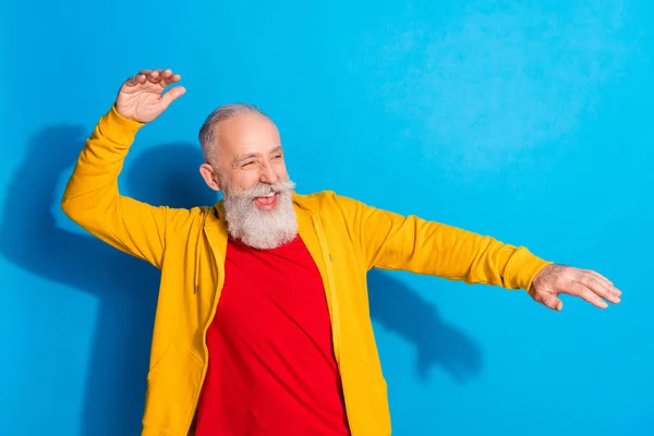 Photo portrait of old man dancing laughing at party looking copyspace isolated on vibrant blue color background