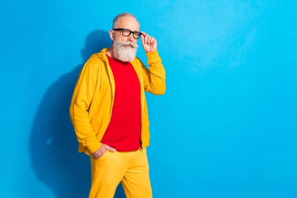 Foto van volwassen cool funky grappig serieus zakenman dragen geel trainingspak en glazen geïsoleerd op blauwe kleur achtergrond — Stockfoto