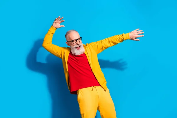 Fotografie šťastného vzrušený bláznivý funky legrační energický dospělý muž tanec s zábavou izolované na modrém pozadí — Stock fotografie