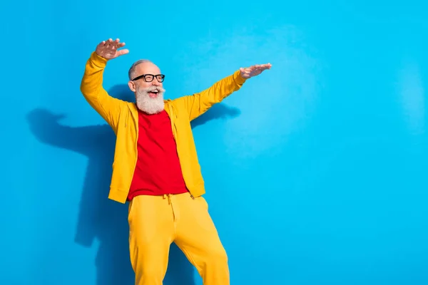 Foto de feliz emocionado alegre guapo abuelo funky en gafas bailando divertirse aislado sobre fondo de color azul —  Fotos de Stock