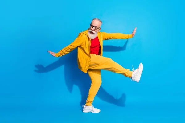 Foto de tamaño completo de loco emocionado positivo funky hombre maduro abuelo bailando engañando aislado sobre fondo de color azul —  Fotos de Stock