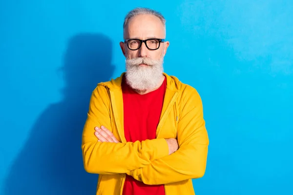 Photo of handsome attractive serious mature businessman in glasses crossed hands isolated on blue color background — Stock Photo, Image