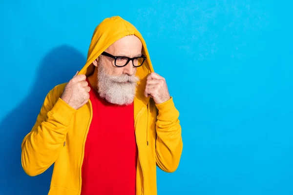 Foto di concentrato concentrato uomo maturo in occhiali look copyspace indossare tuta cappuccio isolato su sfondo di colore blu — Foto Stock