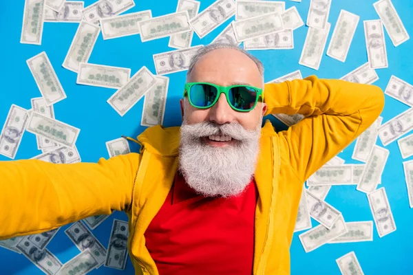 Yüksek açılı mutlu manzaralı fotoğraf büyükbaba mavi arka planda izole edilmiş parayla selfie çektir. — Stok fotoğraf