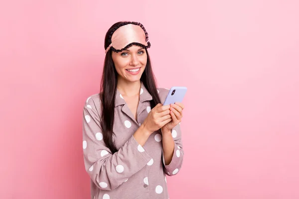 Foto de muito adorável jovem senhora camisola máscara segurando dispositivo moderno isolado cor de fundo rosa — Fotografia de Stock