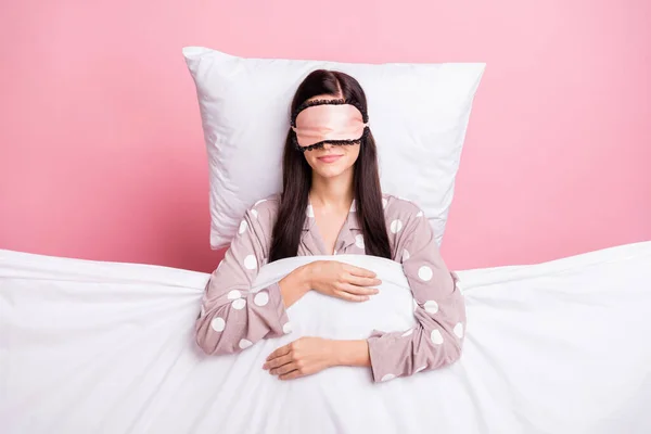 Photo of charming sweet young woman sleepwear mask lying pillow covering duvet isolated pink color background — Stock Photo, Image