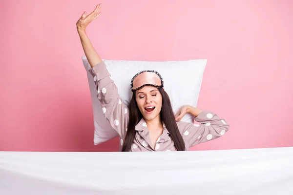 Photo of sleepy pretty woman sleepwear mask lying pillow covering duvet stretching yawning isolated pink color background — Stock Photo, Image