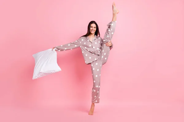 写真の甘い光沢のある若い女性点線ナイトウェア保持枕ダンス立ち上がり脚孤立ピンク色の背景 — ストック写真