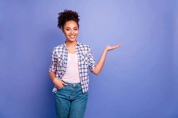 Foto de encantadora mujer joven brillante usar camisa a cuadros sosteniendo brazo vacío espacio aislado color violeta fondo —  Fotos de Stock