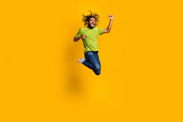Foto retrato cuerpo completo de celebrando chico saltando aislado sobre fondo de color amarillo vivo —  Fotos de Stock