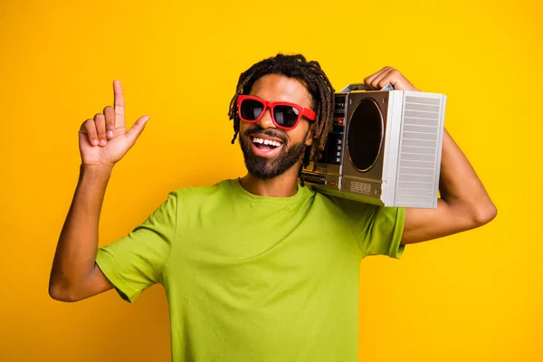 Foto de joven alegre sonrisa feliz hombre mantenga boombox disfrutar de música espectáculo gesto dedo arriba aislado sobre fondo de color amarillo —  Fotos de Stock