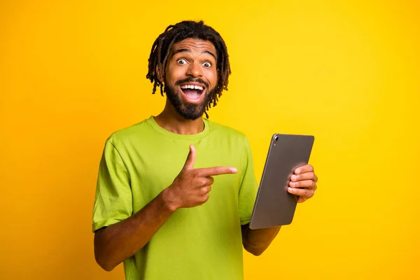 Foto de joven guapo hombre emocionado sonrisa feliz mostrar dedo dedo tableta publicidad consejos de promoción aislado sobre fondo de color amarillo —  Fotos de Stock