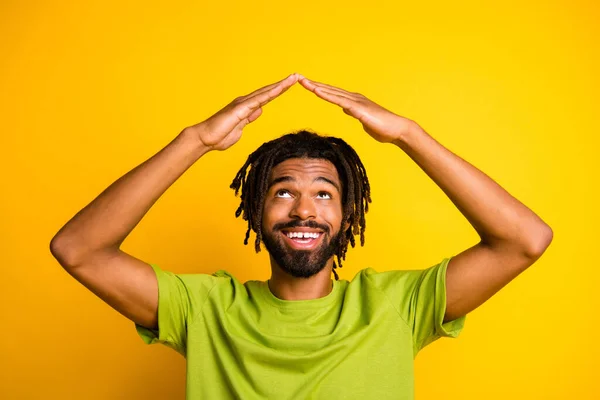 Foto de chico afroamericano sorprendido cogido de la mano cabeza mirada techo seguro casa concepto desgaste camiseta aislada sobre fondo de color amarillo —  Fotos de Stock